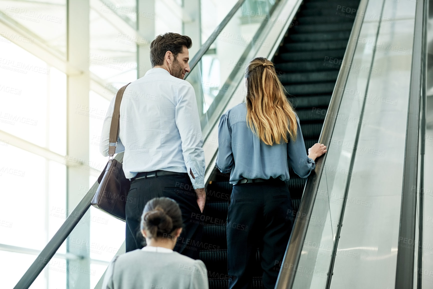 Buy stock photo Office, escalator and back of business people in lobby for meeting, discussion and arrival to seminar. Professional, corporate and man and woman at conference, convention and networking seminar
