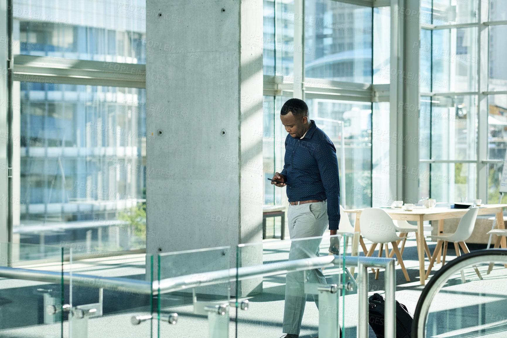 Buy stock photo Black man, phone and walking to escalator at airport, business travel and online for flight info. Male person, pharmaceutical representative and bag for product at seminar, communication and stairs