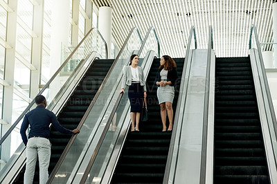 Buy stock photo Office, escalator and business women in discussion in lobby for meeting, arrival and networking. Professional travel, corporate and people on stairs at conference, convention and seminar in building