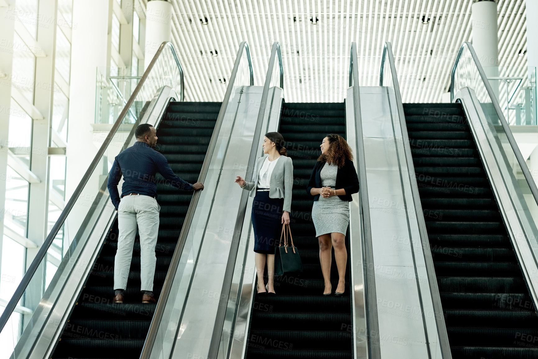 Buy stock photo Office, walking and business people on escalator in lobby for meeting, discussion and networking. Professional, corporate and men and women at conference, convention and seminar in modern building