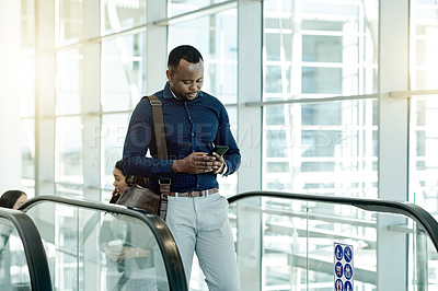 Buy stock photo Phone, lobby and business black man on escalator for commute, travel and arrival in office. Modern building, conference and person on electric stairs with smartphone for contact, connection and email