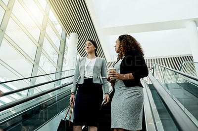 Buy stock photo Office, escalator and business women in morning in lobby for meeting, discussion and conversation. Professional workers, corporate and people at conference, convention and seminar in modern building