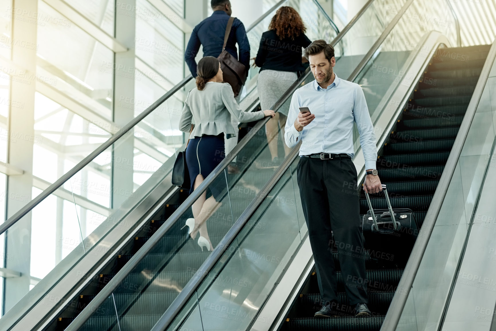 Buy stock photo Man, phone and escalator check in at airport, business travel and online for flight information. Male person, pharmaceutical representative and bag for product at convention, communication and stairs