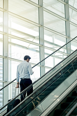 Buy stock photo Escalator, airport and businessman with phone and suitcase for travel, commute and arrival in lobby for trip. Online, contact and person on electric stairs on smartphone for schedule and flight info