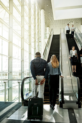 Buy stock photo Escalator, airport and business people in lobby for travel, commute and arrival with luggage. International trip, conference and back of man and woman walking for convention, meeting and seminar