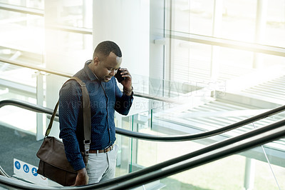 Buy stock photo Phone call, office and business man on escalator for commute, travel and arrival in lobby. Modern building, conference and African person on electric stairs with smartphone for contact and networking