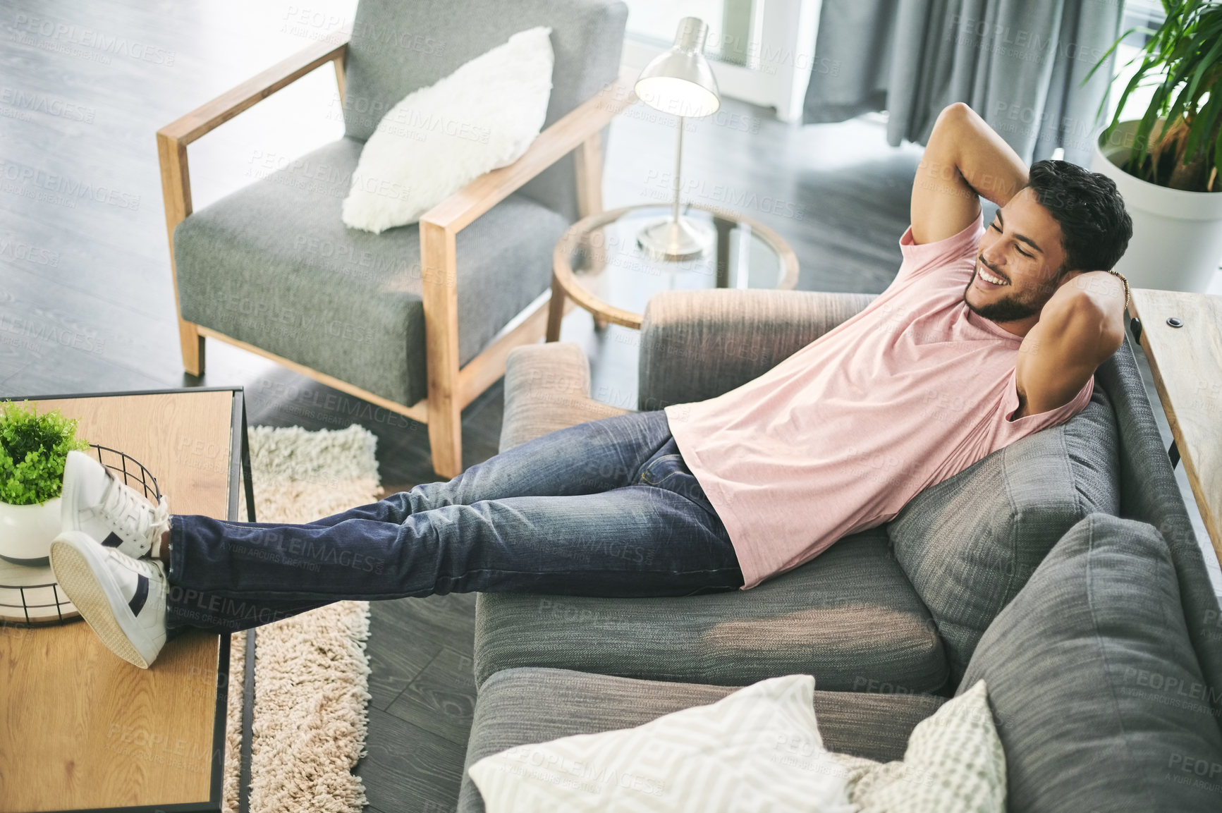 Buy stock photo Happy, home and above of man on sofa for rest, chilling and comfortable on weekend. Living room, relax and person on couch smile for carefree, relaxing and satisfied for vacation, break and holiday
