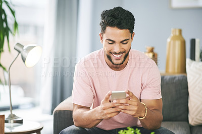 Home, smile and man on sofa, smartphone and typing with social media, funny meme and message to contact. Person, apartment and mobile user with cellphone, online reading and positive email in lounge