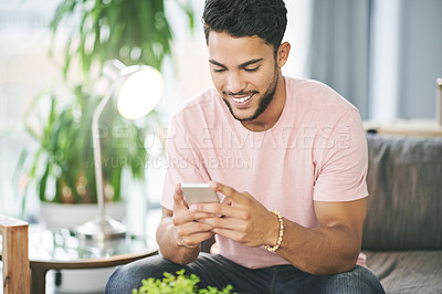 Buy stock photo Home, typing and man on couch, cellphone and smile with social media, text and message to contact. Person, connection and email notification with smartphone, online reading and funny meme in lounge