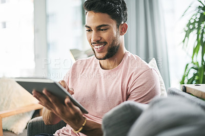 Buy stock photo Man, happy or typing on tablet in home for movie app search, playing online games or text message response. Person, smile or scrolling on digital tech for social media news or internet update on sofa
