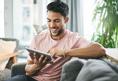 Buy stock photo Relax, tablet and man on sofa in home with online sports chat for fan polls with match update. Happy, digital technology and male person reading tournament results on blog in living room at house.