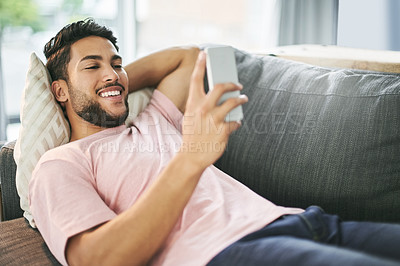 Buy stock photo House, relax and man on sofa, smartphone and typing with social media, texting and message to contact. Person, apartment and mobile user with cellphone, online reading and funny meme in living room