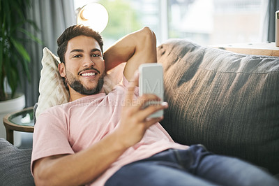 Buy stock photo Man, portrait and relax on sofa with phone, social media and comfort with online banking in home. Person, chill and mobile on couch for streaming platform, ecommerce app review and forum discussion