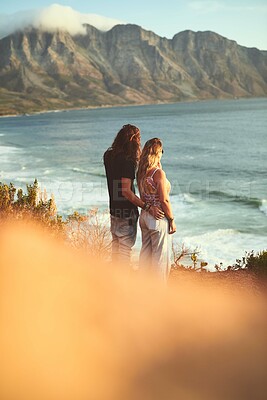 Buy stock photo Ocean, mountain and couple with hug on vacation, travel holiday and bonding together with embrace. Outdoor, man and woman with water view for anniversary, connection and adventure with love by flare