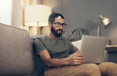 Buy stock photo Remote work, laptop and man on sofa for online project, social networking and reading email. Freelancer, It support and person on computer for website review, tech service and working from home