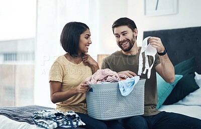 Buy stock photo Laundry, fold clothes and couple in bedroom for cleaning, chore routine and hygiene in home. Marriage, relationship and happy man and woman with washing basket for housekeeping, helping and housework