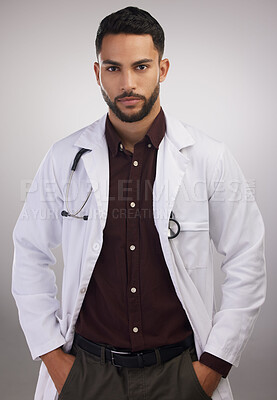 Buy stock photo Portrait, man and doctor in studio for healthcare, medical and staff in lab coat by grey background. Professional male person, stethoscope and career in clinic with pride for medicine and wellness 