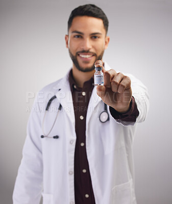 Buy stock photo Portrait, doctor and holding vaccine in studio for healthcare, medical and man in lab coat by grey background. Professional male person, stethoscope and bottle in clinic with pride for medicine 