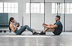Active, sporty fitness couple or gym partners training together, doing abs exercises with a weighted slam ball. Male trainer and female athlete having a fun workout session or class.