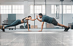Fitness partners exercising together and doing pushups high five at the gym. Fit and active man and woman training in a health facility as part of their workout routine. A couple doing an exercise