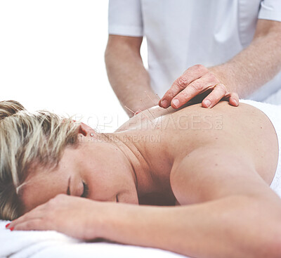 Buy stock photo A young woman getting needles inserted into her back during an acupuncture session. A patient getting alternative therapy for medical treatment