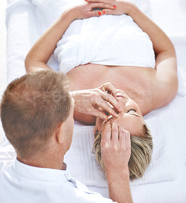 Buy stock photo A young woman getting needles inserted into her head during an acupuncture session. A patient getting alternative therapy for medical treatment