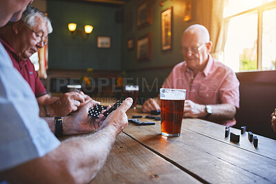Buy stock photo Group of senior men sitting together and playing dominoes in a bar, bonding, strategy game, senior friends enjoying a game of dominoes in a pub