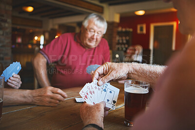 Buy stock photo Unknown senior man sitting with friends and playing card games in a bar, bonding, senior friends enjoying a game of bridge in a pub