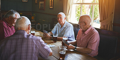 Buy stock photo Group of senior men sitting together and playing card games in a bar, bonding, senior friends enjoying a game of bridge in a pub