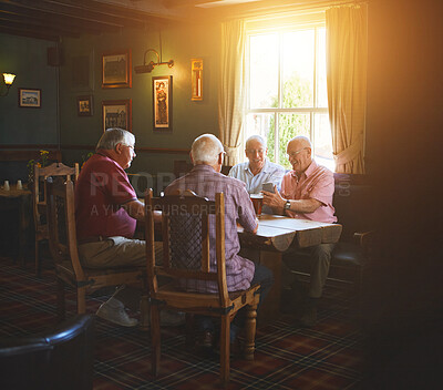 Buy stock photo Two senior men sitting with friends and using a cellphone in a bar, bonding, senior friends browsing online, social media, social networking