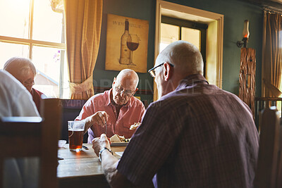 Buy stock photo Senior man sitting with friends and enjoying lunch in a bar. Elderly men bonding eating lunch in a pub, senior friends
