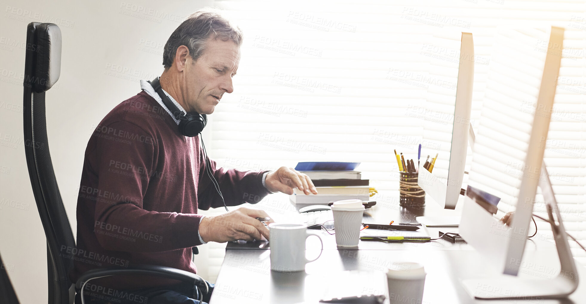 Buy stock photo A businessman using a computer in a modern office. A mature male executive working online for business at his desk