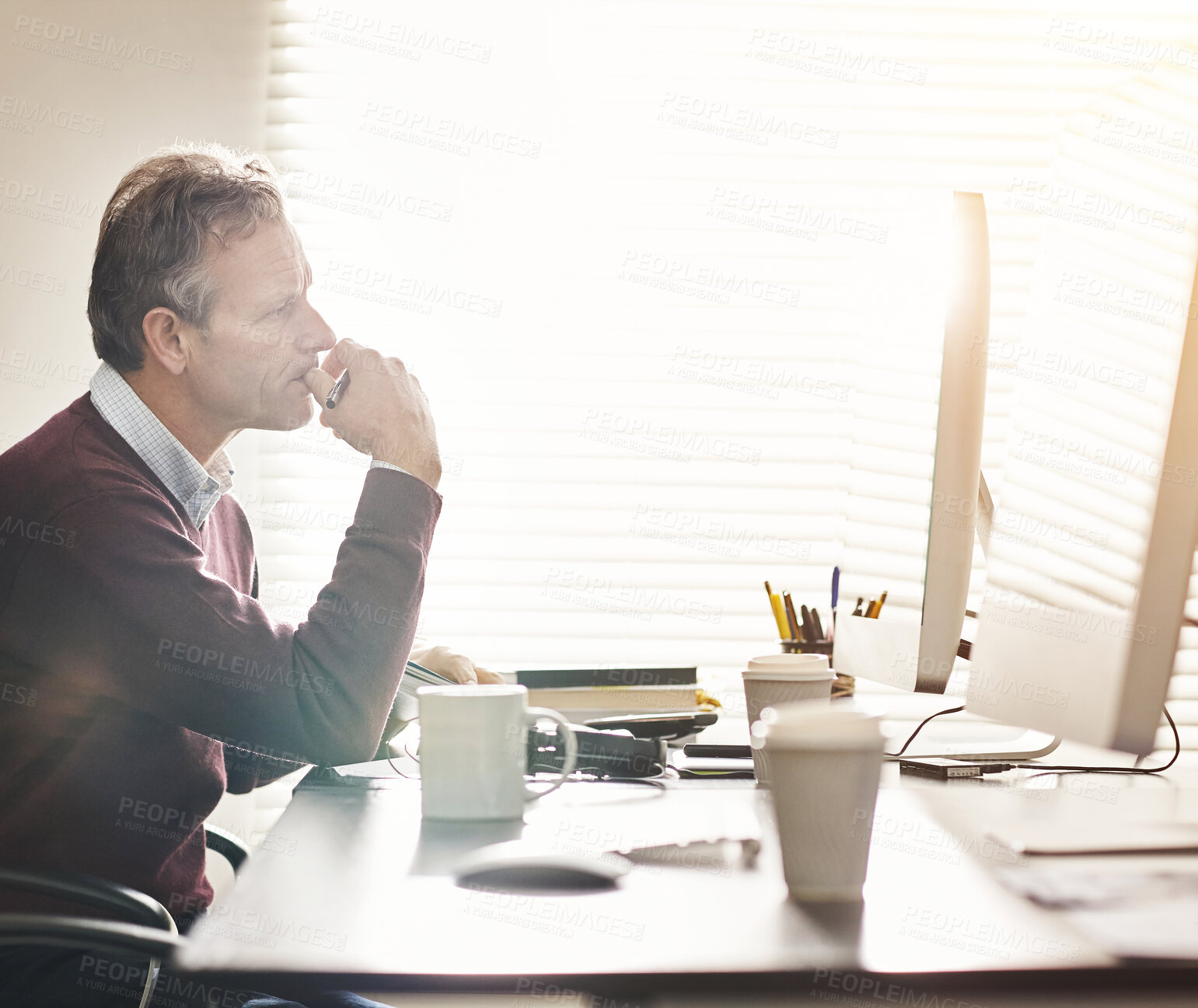 Buy stock photo A businessman using a computer in a modern office. A mature male executive working online for business at his desk