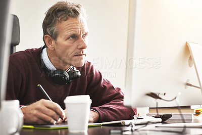 Buy stock photo A businessman using a digital tablet in a modern office. A mature male executive working online for business with a touchscreen