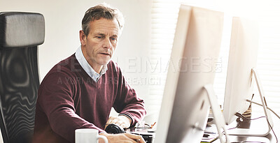 Buy stock photo A businessman using a computer in a modern office. A mature male executive working online for business at his desk