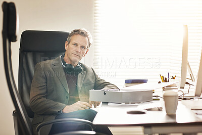 Buy stock photo Portrait of a mature businessman working in a modern office. A mature male executive sitting and working on his business at a desk