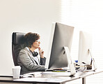 A businesswoman using a computer in a modern office. A mature female executive working online for business at her desk