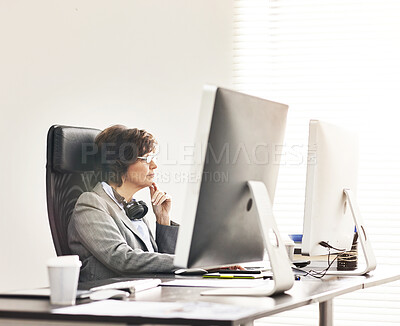 Buy stock photo A businesswoman using a computer in a modern office. A mature female executive working online for business at her desk