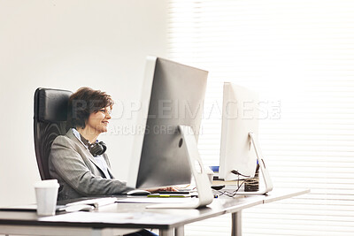 Buy stock photo A businesswoman using a computer in a modern office. A mature female executive working online for business at her desk