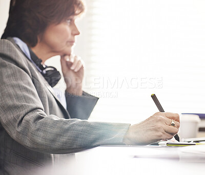Buy stock photo A businesswoman using a digital tablet in a modern office. A mature female executive working online for business with a touchscreen
