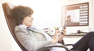 Buy stock photo A businesswoman using a phone in a modern office. A mature female executive browsing online for business with her smartphone at work
