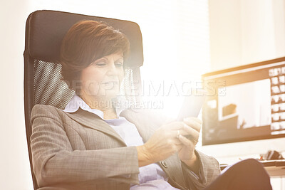 Buy stock photo A businesswoman using a phone in a modern office. A mature female executive browsing online for business with her smartphone at work