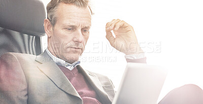 Buy stock photo A businessman using a digital tablet in a modern office. A mature male executive browsing online for business with a touchscreen at work