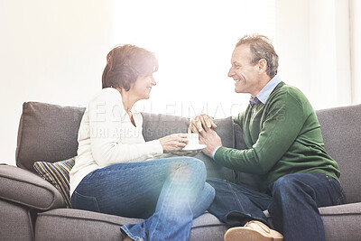 Buy stock photo A mature couple relaxing at home. A happy senior man and woman in love, having a coffee or tea break, sharing a cosy moment on the couch