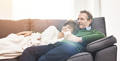 Buy stock photo A mature couple relaxing at home. A happy senior man and woman in love, having a coffee or tea break, sharing a cosy moment on the couch