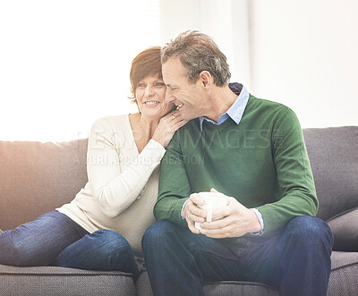 Buy stock photo A mature couple relaxing at home. A happy senior man and woman in love, having a coffee or tea break, sharing a cosy moment on the couch