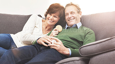 Buy stock photo A mature couple relaxing at home. A happy senior man and woman in love, having a coffee or tea break, sharing a cosy moment on the couch