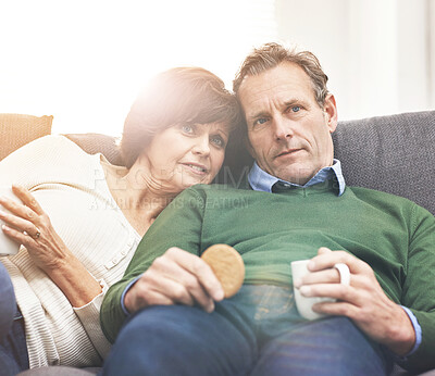 Buy stock photo A mature couple relaxing at home. A happy senior man and woman in love, having a coffee or tea break, sharing a cosy moment on the couch