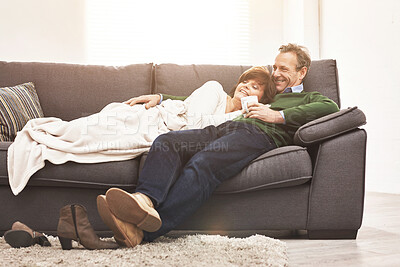 Buy stock photo A mature couple relaxing at home. A happy senior man and woman in love, having a coffee or tea break, sharing a cosy moment on the couch