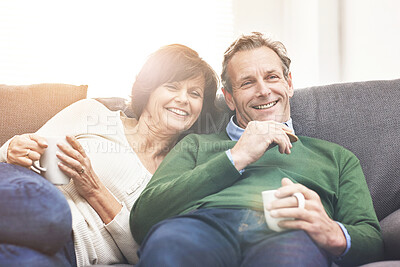 Buy stock photo A mature couple relaxing at home. A happy senior man and woman in love, having a coffee or tea break, sharing a cosy moment on the couch